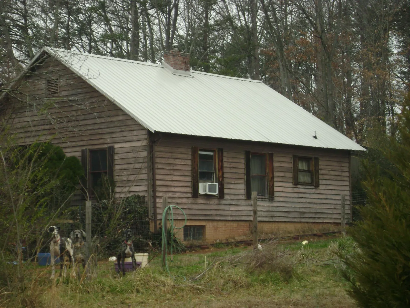 White metal roof on an old wood sided farmhouse, from a Metal Roof Installation job in Millersburg